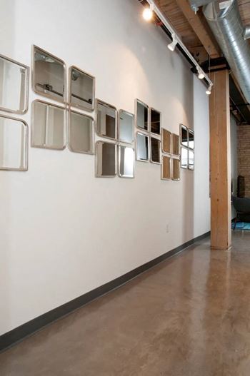 A wall with a series of square mirrors on it.